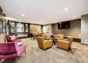 Thumbnail 10 of 36 - The Hayes on Stone Way Apartments  lounge area with chairs and tables and a television at The Hayes on Stone Way, Seattle, Washington