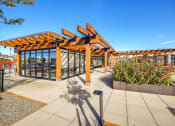 Thumbnail 11 of 36 - a covered patio with flowers and a glass building with a roofat The Hayes on Stone Way, Seattle