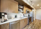 Thumbnail 4 of 36 - a kitchen with wooden cabinets and stainless steel appliances at The Hayes on Stone Way, Washington