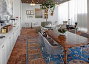 Thumbnail 16 of 35 - A dining room with a wooden table surrounded by chairs.