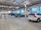 Thumbnail 18 of 35 - A parking garage with several cars parked inside.