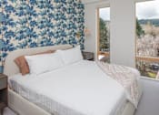 Thumbnail 8 of 35 - A bedroom with a large bed and a view of the outdoors through a window.