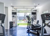 Thumbnail 17 of 24 - A gym with treadmills and elliptical machines.
