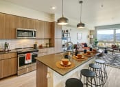 Thumbnail 3 of 48 - a kitchen with a large island with a breakfast bar and a living room with a couch and