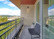 Thumbnail 9 of 48 - a balcony with a chair and a potted plant