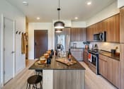 Thumbnail 2 of 48 - a kitchen with wooden cabinetry and a large island with a breakfast bar