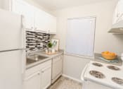 Thumbnail 6 of 7 - A kitchen with white appliances and cabinets.