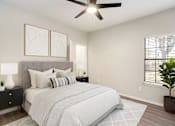 Thumbnail 3 of 7 - A bedroom with a large bed, a ceiling fan, and two wall lamps.