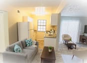 Thumbnail 5 of 7 - A living room with a grey couch and a wooden coffee table.