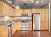 Thumbnail 3 of 29 - A kitchen with wooden cabinets and stainless steel appliances.