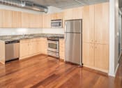 Thumbnail 7 of 29 - A kitchen with wooden cabinets and stainless steel appliances.