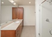 Thumbnail 14 of 29 - A bathroom with a sink, mirror, and wooden cabinet.