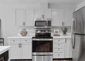 Thumbnail 2 of 43 - a kitchen with white cabinets and stainless steel appliances