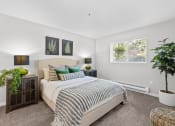 Thumbnail 8 of 43 - a bedroom with a large bed and plants on the side of the bed