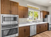 Thumbnail 42 of 43 - a kitchen with wooden cabinets and stainless steel appliances