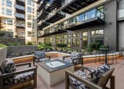 Thumbnail 22 of 26 - Vela Apartments  outdoor patio with a firepit and lounge chairs