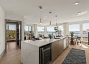 Thumbnail 2 of 26 - Vela Apartments kitchen and living room with a view of the water