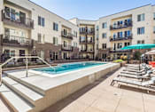 Thumbnail 20 of 23 - A swimming pool in front of apartment buildings.