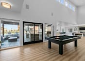 Thumbnail 9 of 48 - a living room with a pool table in the middle of it