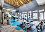 Thumbnail 10 of 20 - A spacious gym with a variety of equipment including treadmills, weights, and exercise machines.