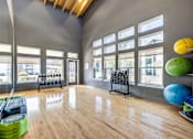Thumbnail 11 of 20 - A gym with a wooden floor and a bench outside the window.