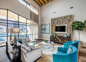 Thumbnail 6 of 20 - A living room with a blue armchair and a grey couch.