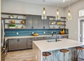Thumbnail 8 of 20 - A kitchen with a white counter top and wooden bar stools.
