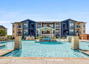 Thumbnail 15 of 20 - A large swimming pool in front of a modern apartment building.