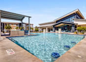 Thumbnail 17 of 20 - A swimming pool with a building in the background.