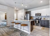 Thumbnail 1 of 20 - A kitchen with a white island and bar stools.