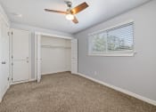 Thumbnail 5 of 8 - North River Apartments bedroom with a ceiling fan and a window and a closet