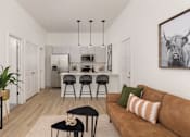 Thumbnail 1 of 12 - a living room with a couch and a kitchen with a