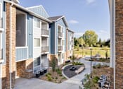 Thumbnail 12 of 12 - an exterior view of an apartment building with a pathway and landscaping