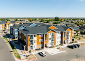 Thumbnail 11 of 12 - an aerial view of an apartment complex with cars parked in front of it