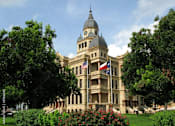 Thumbnail 27 of 27 - a large building with a clock tower and a flag on the front at Urban Square, Denton, TX