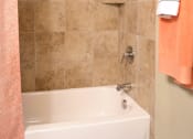 Thumbnail 12 of 27 - a bathroom with a shower and a tub and a towel at Urban Square, Denton, TX