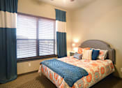 Thumbnail 10 of 27 - a bedroom with a bed and a large window at Urban Square, Denton, TX, 76210