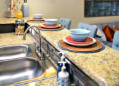 Thumbnail 5 of 27 - a kitchen with a sink and a counter with plates on it at Urban Square, Texas