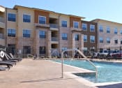 Thumbnail 19 of 27 - a swimming pool with a building in the background at Urban Square, Denton, 76210