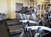 Thumbnail 23 of 27 - a gym with cardio equipment and weights in a building at Urban Square, Denton, Texas, 76210