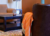 Thumbnail 20 of 27 - a living room with a brown chair and a television at Urban Square, Denton, TX, 76210