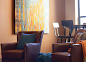 Thumbnail 24 of 27 - a living room with leather chairs and a painting on the wall at Urban Square, Denton, Texas