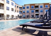 Thumbnail 13 of 27 - our apartments have a large pool and lounge chairs at Urban Square, Denton, TX, 76210