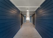 Thumbnail 2 of 11 - A long, narrow hallway with a light at the end.