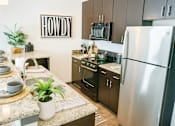 Thumbnail 2 of 19 - A kitchen with a Howdy sign on the wall.