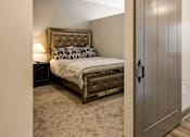 Thumbnail 15 of 27 - A bedroom with a bed, nightstand, and a sliding door. at 985 High Apartments, Columbus, OH, 43201