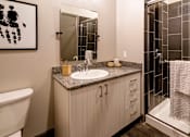 Thumbnail 17 of 27 - A bathroom with a sink, mirror, and towel rack. at 985 High Apartments, Ohio, 43201