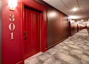 Thumbnail 19 of 27 - A hallway with red doors and a number 301 on the wall. at 985 High Apartments, Columbus