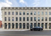 Thumbnail 18 of 20 - a large building with a car parked in front of it
