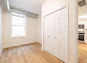 Thumbnail 11 of 20 - an empty living room with a white door and a window